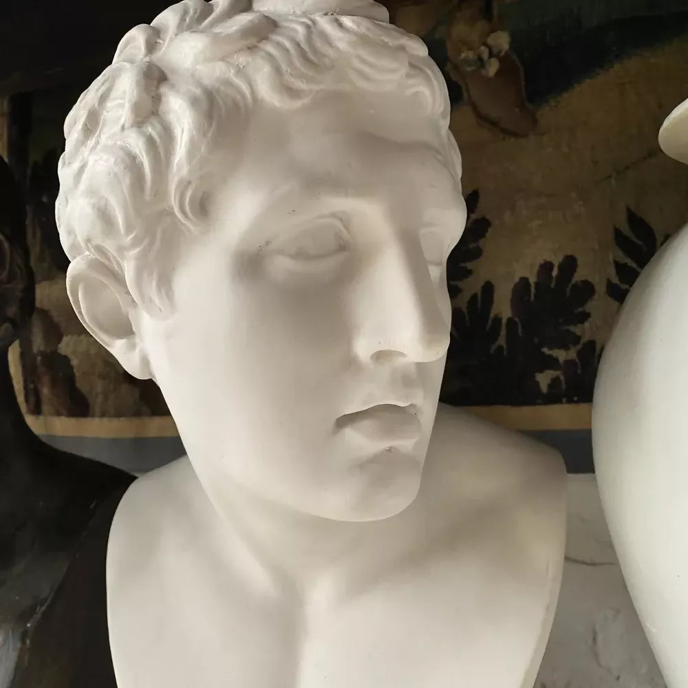 White marble bust on a pedestal with decorative wall in the background available to buy from the-salon.com. SALON curates the finest unique handmade pieces from the interior industry's best makers and brands. Shop luxury furniture, lighting, rugs, art, antiques and vintage pieces and accessories from SALON interior designed rooms.