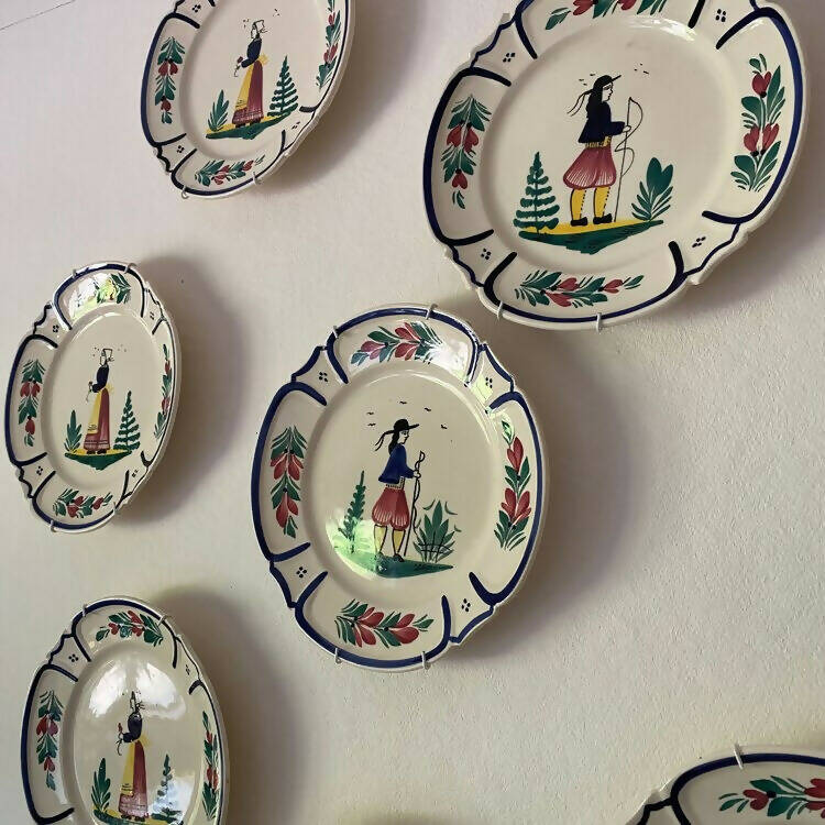 A set of vintage French hand painted plates with a man and woman motif, displayed on a wall,  available  to buy on the-salon.com. SALON curates the finest , unique, handmade pieces from the interior industry's best makers and brands. Shop luxury furniture, lighting, rugs, art, antiques and vintage pieces and accessories from SALON interior designed rooms.