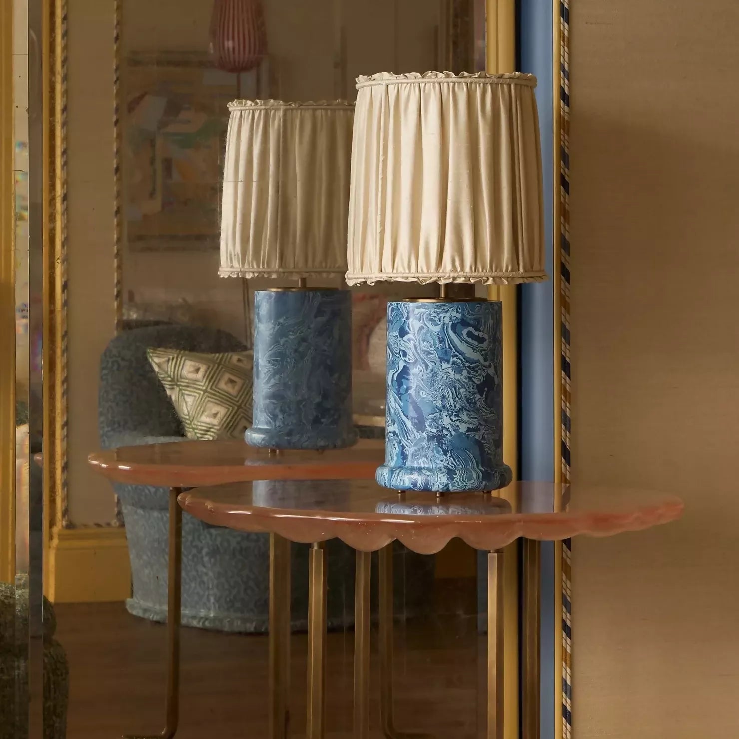 A blue marbled base table lamp with brass detailing, topped with a gold pleated shade,  available  to buy on the-salon.com. SALON curates the finest , unique, handmade pieces from the interior industry's best makers and brands. Shop luxury furniture, lighting, rugs, art, antiques and vintage pieces and accessories from SALON interior designed rooms.