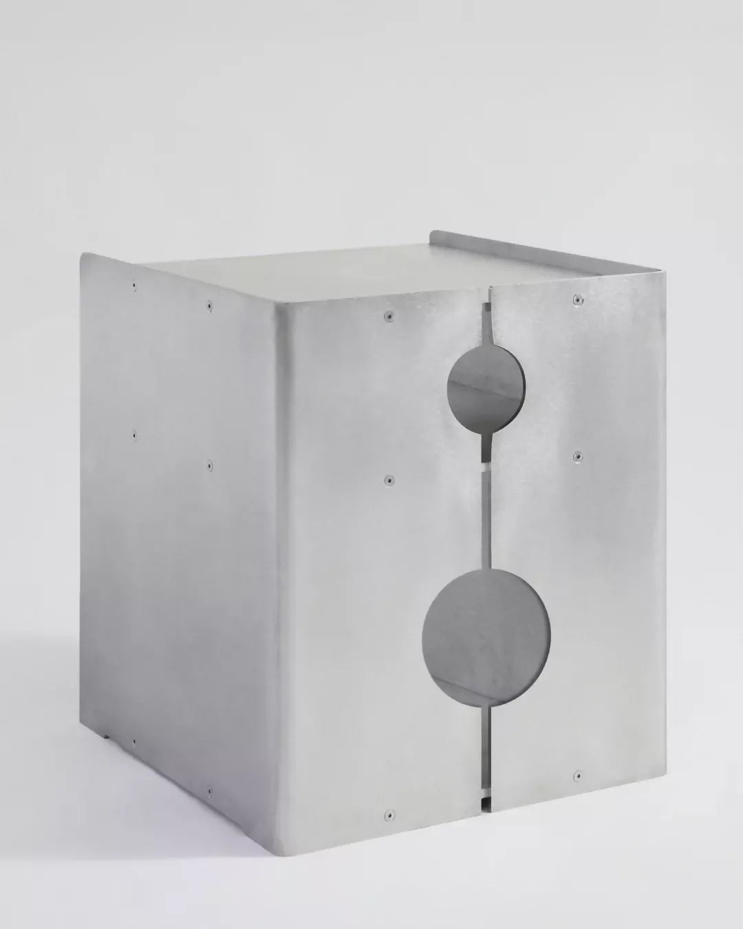A minimalist silver aluminum media storage cabinet with a hole in the center and multiple shelves,  available  to buy on the-salon.com. SALON curates the finest , unique, handmade pieces from the interior industry's best makers and brands. Shop luxury furniture, lighting, rugs, art, antiques and vintage pieces and accessories from SALON interior designed rooms.