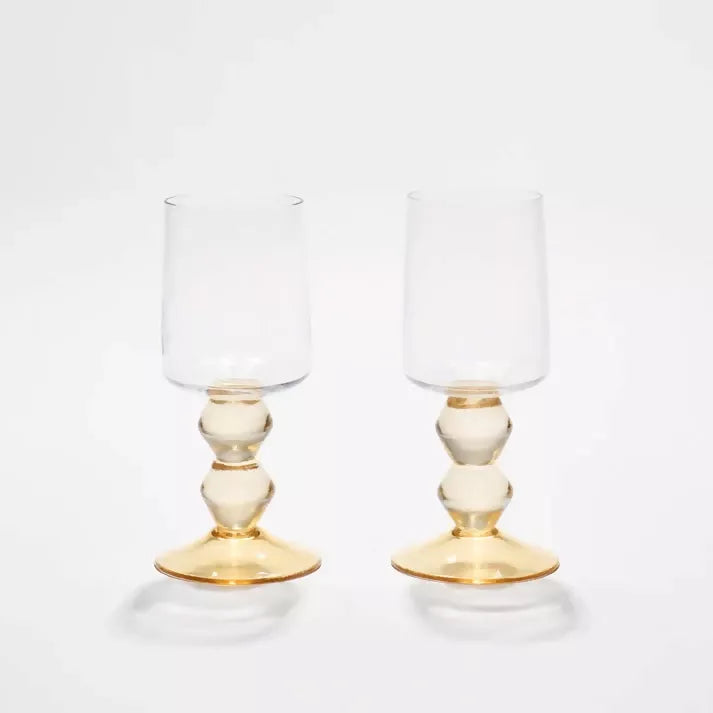 Two clear glasses with gold bases on a white background, available  to buy on the-salon.com. SALON curates the finest , unique, handmade pieces from the interior industry's best makers and brands. Shop luxury furniture, lighting, rugs, art, antiques and vintage pieces and accessories from SALON interior designed rooms.