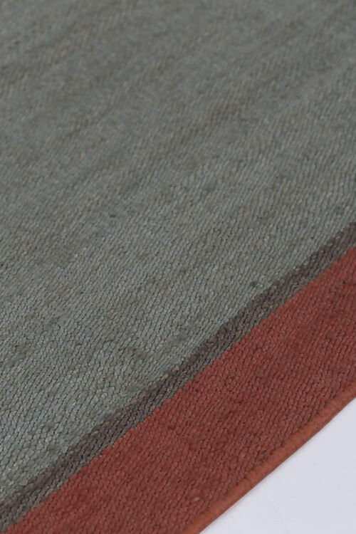 Close-up view of a hand-woven dhurrie rug with a plain texture and a visible border, available  to buy on the-salon.com. SALON curates the finest , unique, handmade pieces from the interior industry's best makers and brands. Shop luxury furniture, lighting, rugs, art, antiques and vintage pieces and accessories from SALON interior 