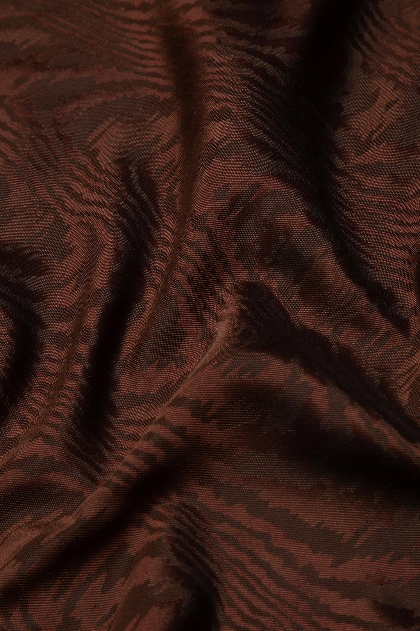 Close-up view of a brown moiré patterned fabric,  available  to buy on the-salon.com. SALON curates the finest , unique, handmade pieces from the interior industry's best makers and brands. Shop luxury furniture, lighting, rugs, art, antiques and vintage pieces and accessories from SALON interior designed rooms.