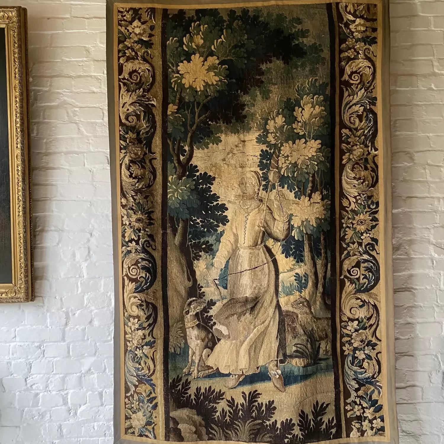 Decorative tapestry with a woman and forest design on a white brick wall,  available  to buy on the-salon.com. SALON curates the finest , unique, handmade pieces from the interior industry's best makers and brands. Shop luxury furniture, lighting, rugs, art, antiques and vintage pieces and accessories from SALON interior designed rooms.