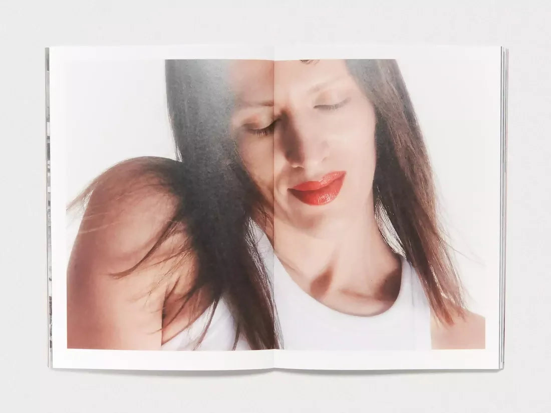 An open book, a large image of a woman with red lipstick infront of a white backdrop,  available  to buy on the-salon.com. SALON curates the finest , unique, handmade pieces from the interior industry's best makers and brands. Shop luxury furniture, lighting, rugs, art, antiques and vintage pieces and accessories from SALON interior designed rooms.