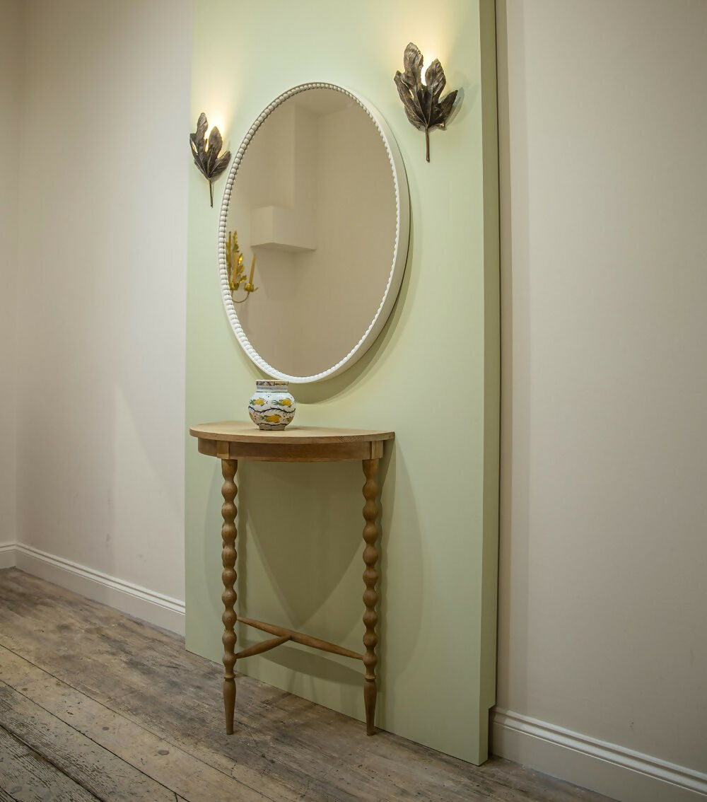 A bronze wall light fixture designed to resemble a fig leaf, with a textured surface and a wall mounting bracket,  available  to buy on the-salon.com. SALON curates the finest , unique, handmade pieces from the interior industry's best makers and brands. Shop luxury furniture, lighting, rugs, art, antiques and vintage pieces and accessories from SALON interior designed rooms.