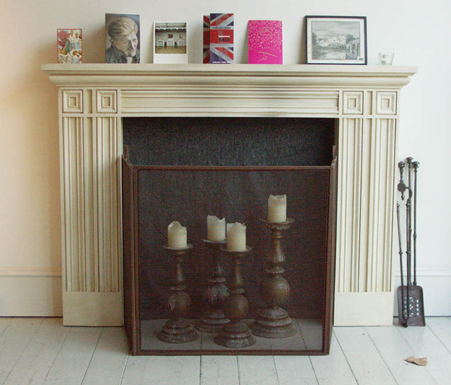 An image of a white fireplace with candles and photographs ontop,  available  to buy on the-salon.com. SALON curates the finest , unique, handmade pieces from the interior industry's best makers and brands. Shop luxury furniture, lighting, rugs, art, antiques and vintage pieces and accessories from SALON interior designed rooms.