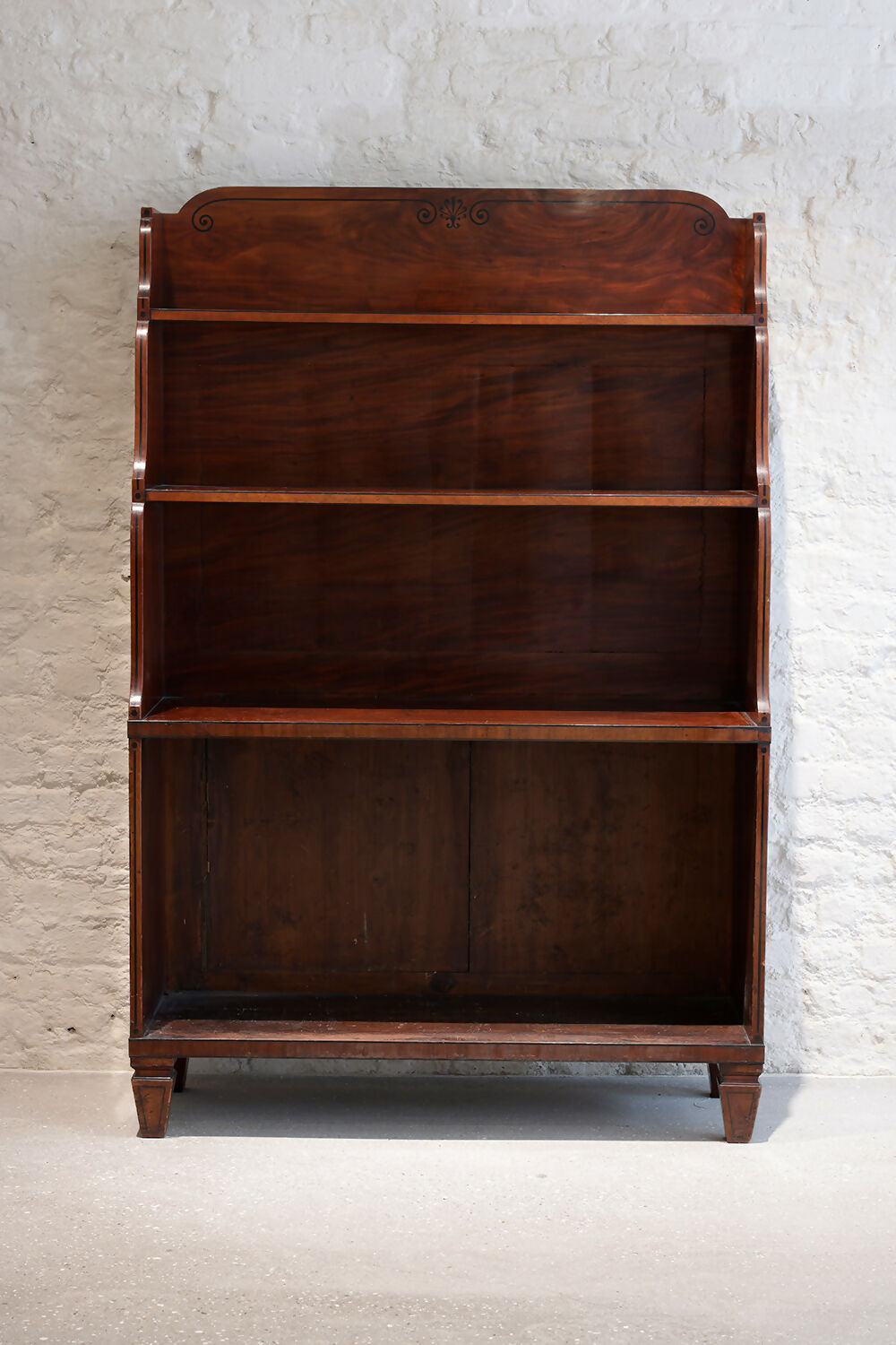 A REGENCY MAHOGANY AND EBONY INLAID WATERFALL BOOKCASE