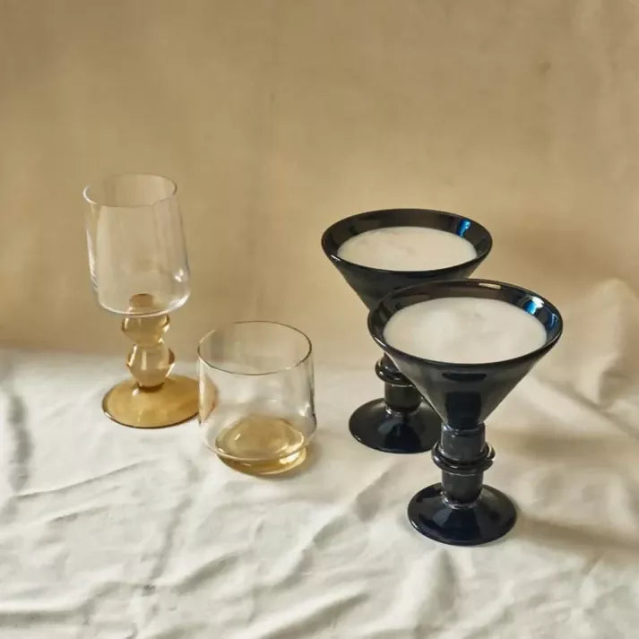 Four Glasses, two with gold bottoms and two fully black on a white backdrop, available  to buy on the-salon.com. SALON curates the finest , unique, handmade pieces from the interior industry's best makers and brands. Shop luxury furniture, lighting, rugs, art, antiques and vintage pieces and accessories from SALON interior designed rooms.
