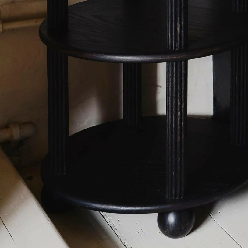 Black wooden legs, close-up, against a plain background, available  to buy on the-salon.com. SALON curates the finest , unique, handmade pieces from the interior industry's best makers and brands. Shop luxury furniture, lighting, rugs, art, antiques and vintage pieces and accessories from SALON interior designed rooms.