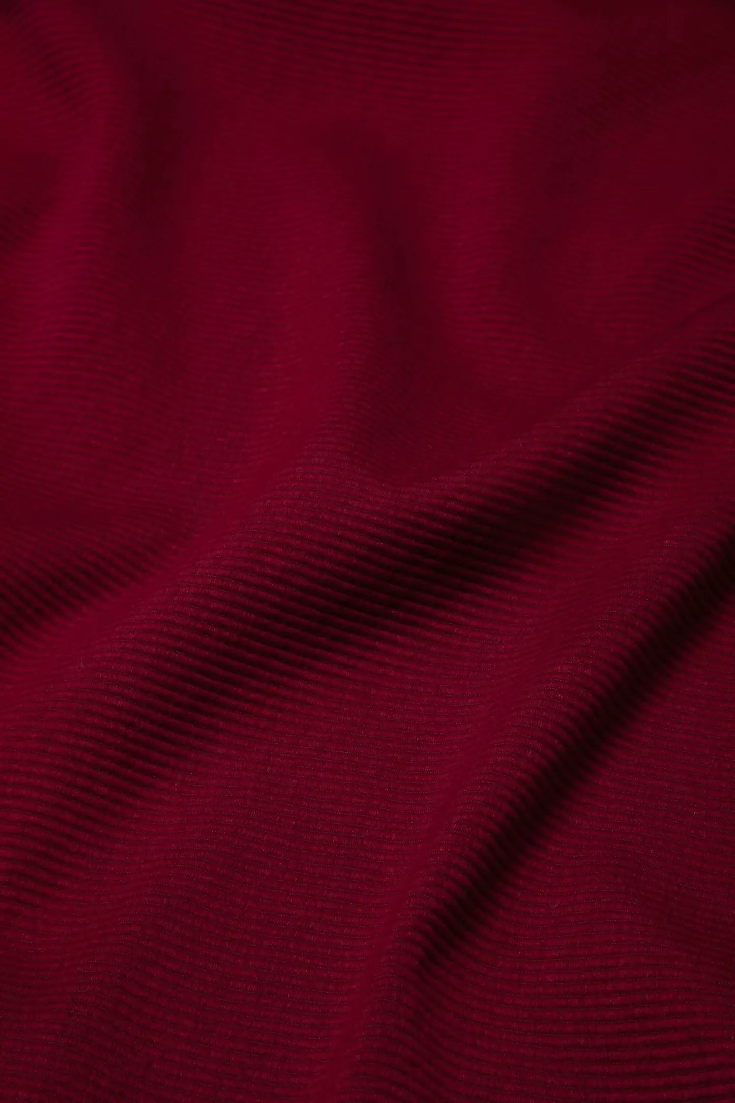 Close-up view of a red fabric with a textured weave pattern suitable for upholstery,  available  to buy on the-salon.com. SALON curates the finest , unique, handmade pieces from the interior industry's best makers and brands. Shop luxury furniture, lighting, rugs, art, antiques and vintage pieces and accessories from SALON interior designed rooms.