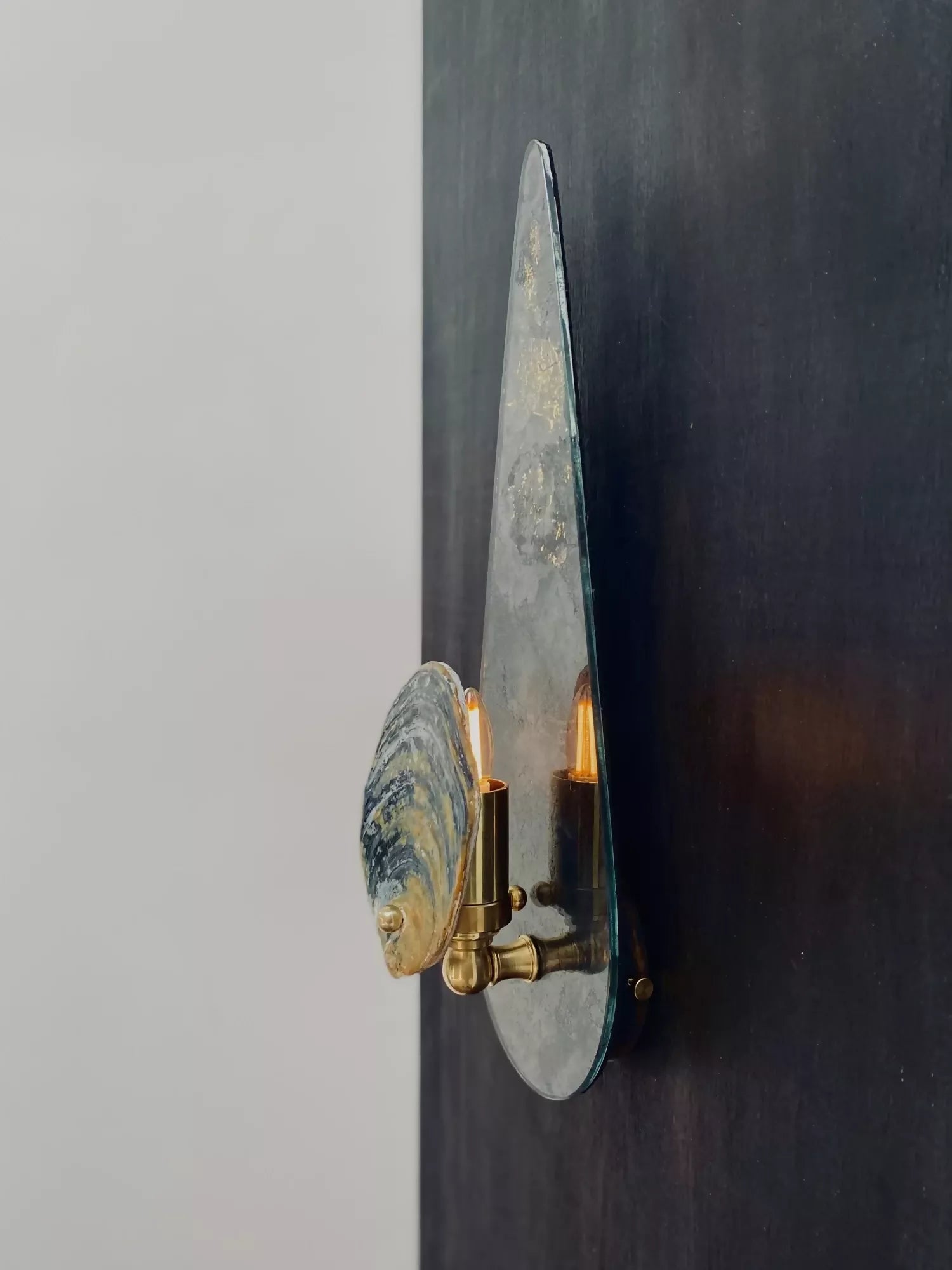 Decorative wall sconce with marbleized design on a dark wall.