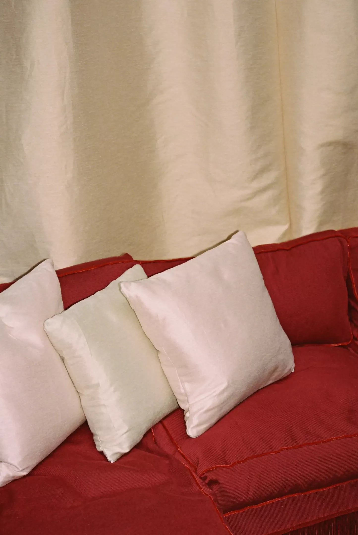 A view of a silk sateen fabric in a pale green colour, showing the texture and sheen as curtains,  available  to buy on the-salon.com. SALON curates the finest , unique, handmade pieces from the interior industry's best makers and brands. Shop luxury furniture, lighting, rugs, art, antiques and vintage pieces and accessories from SALON interior designed rooms.