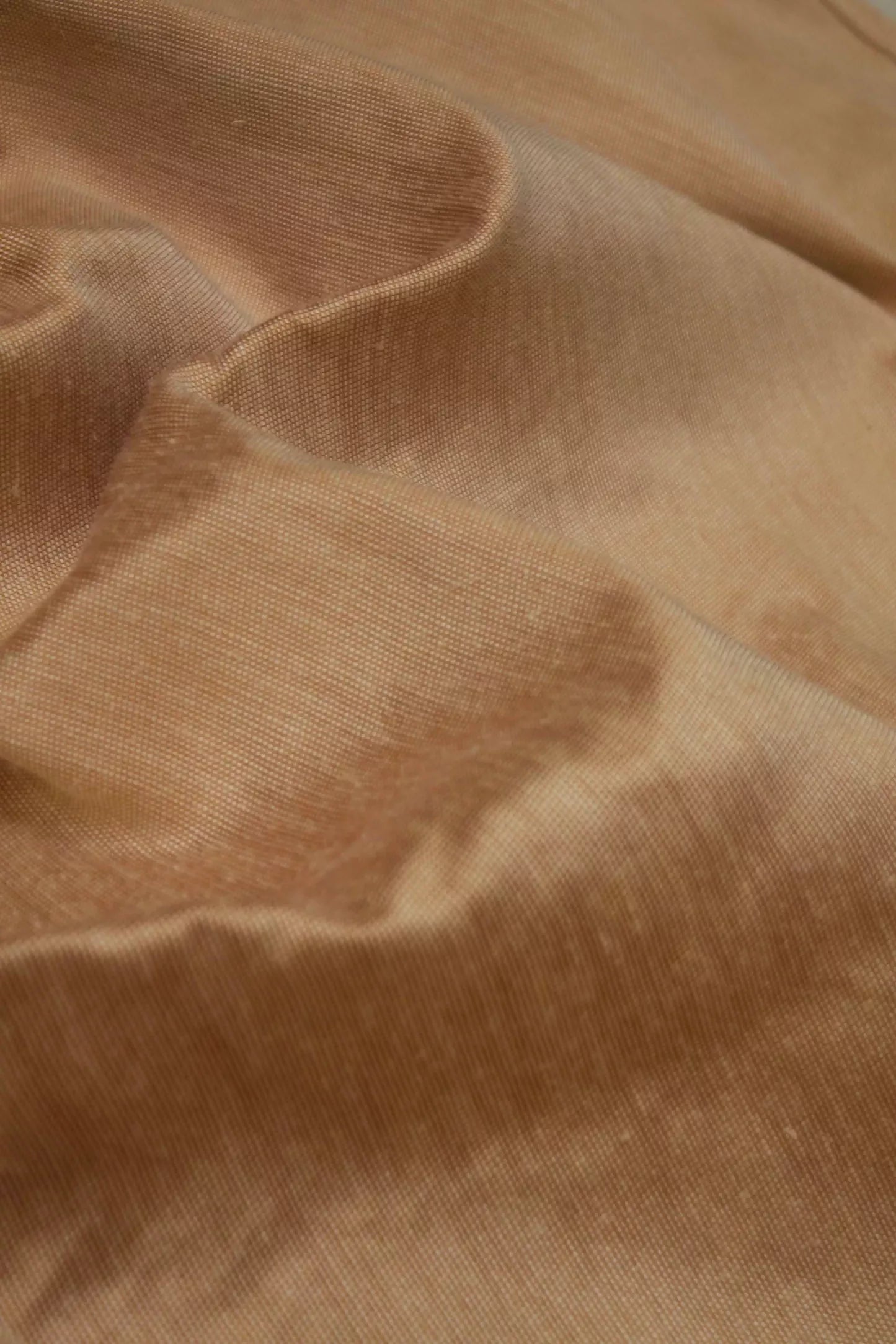 Close-up of a silk sateen fabric in a mottled red and orange color, with a slight sheen from the silk content,  available  to buy on the-salon.com. SALON curates the finest , unique, handmade pieces from the interior industry's best makers and brands. Shop luxury furniture, lighting, rugs, art, antiques and vintage pieces and accessories from SALON interior designed rooms.