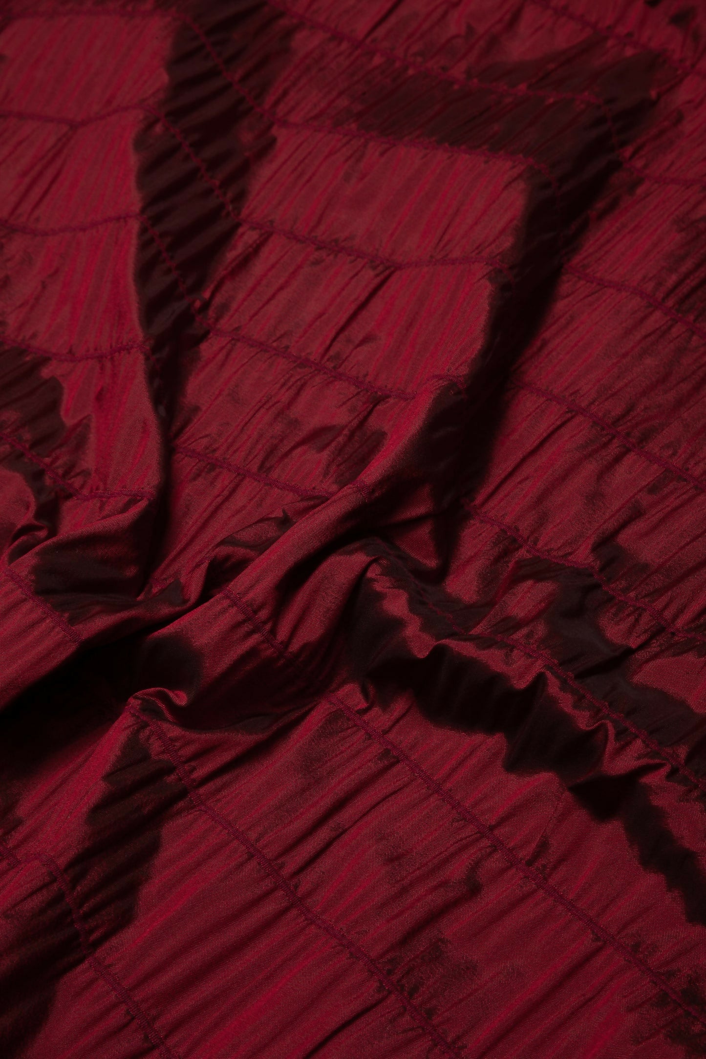 Close-up of a red textured fabric with subtle rouches, woven in the UK,  available  to buy on the-salon.com. SALON curates the finest , unique, handmade pieces from the interior industry's best makers and brands. Shop luxury furniture, lighting, rugs, art, antiques and vintage pieces and accessories from SALON interior designed rooms.