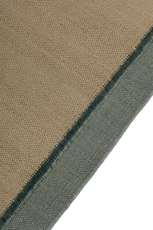 Close-up view of a hand-woven dhurrie rug with a plain texture and a visible border, available  to buy on the-salon.com. SALON curates the finest , unique, handmade pieces from the interior industry's best makers and brands. Shop luxury furniture, lighting, rugs, art, antiques and vintage pieces and accessories from SALON interior d