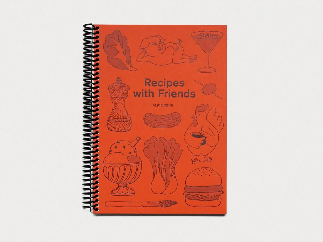 A spiral-bound cookbook with an orange cover featuring illustrations of kitchenware and food items, titled 'Recipes with Friends', available  to buy on the-salon.com. SALON curates the finest , unique, handmade pieces from the interior industry's best makers and brands. Shop luxury furniture, lighting, rugs, art, antiques and vintage pieces and accessories from SALON interior designed rooms.