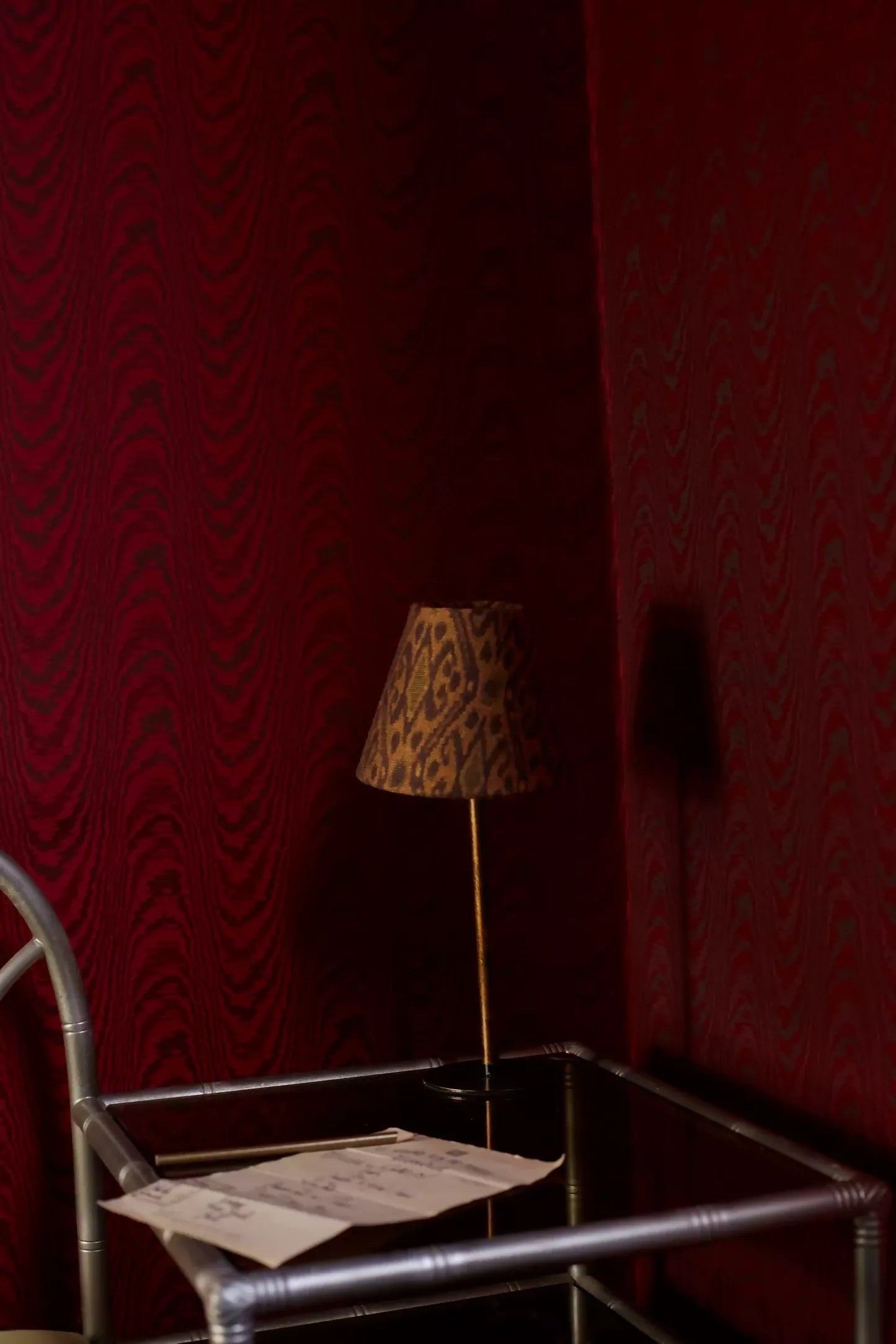 Close-up of a woven ikat fabric in shades of brown, with a geometric pattern featuring Tiger's Eye stone-like iridescence, on a lampshade,  available  to buy on the-salon.com. SALON curates the finest , unique, handmade pieces from the interior industry's best makers and brands. Shop luxury furniture, lighting, rugs, art, antiques and vintage pieces and accessories from SALON interior designed rooms.