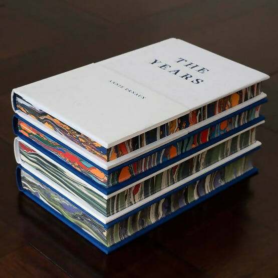A limited edition hardback collection of books, casebound in fine linen cloth with custom marbled endpapers, titled 'The Years'. The set includes several volumes with visible titles and author names on the spine, available  to buy on the-salon.com. SALON curates the finest , unique, handmade pieces from the interior industry's best makers and brands. Shop luxury furniture, lighting, rugs, art, antiques and vintage pieces and accessories from SALON interior designed rooms.