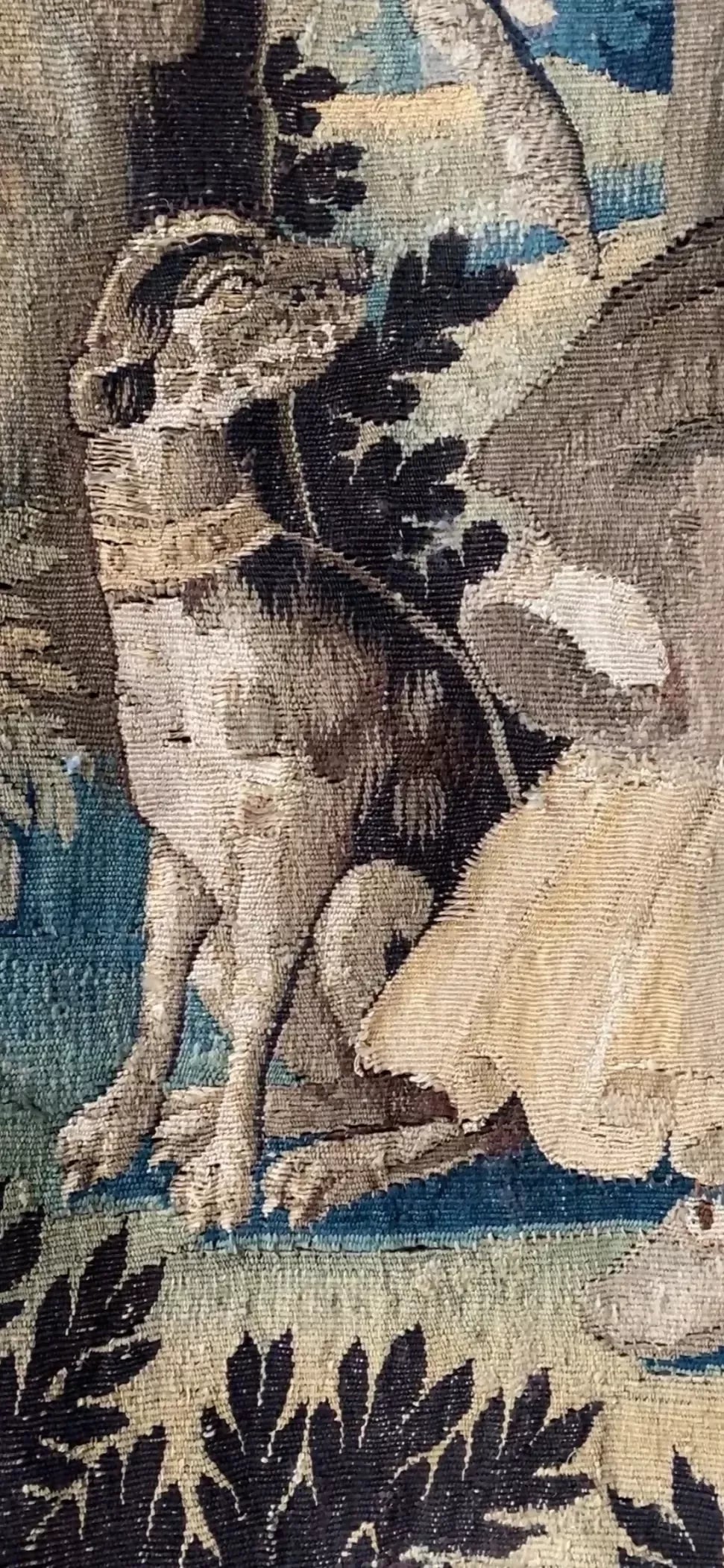Close up of a dog on a  decorative tapestry with a woman and forest design on a white brick wall,  available  to buy on the-salon.com. SALON curates the finest , unique, handmade pieces from the interior industry's best makers and brands. Shop luxury furniture, lighting, rugs, art, antiques and vintage pieces and accessories from SALON interior designed rooms.