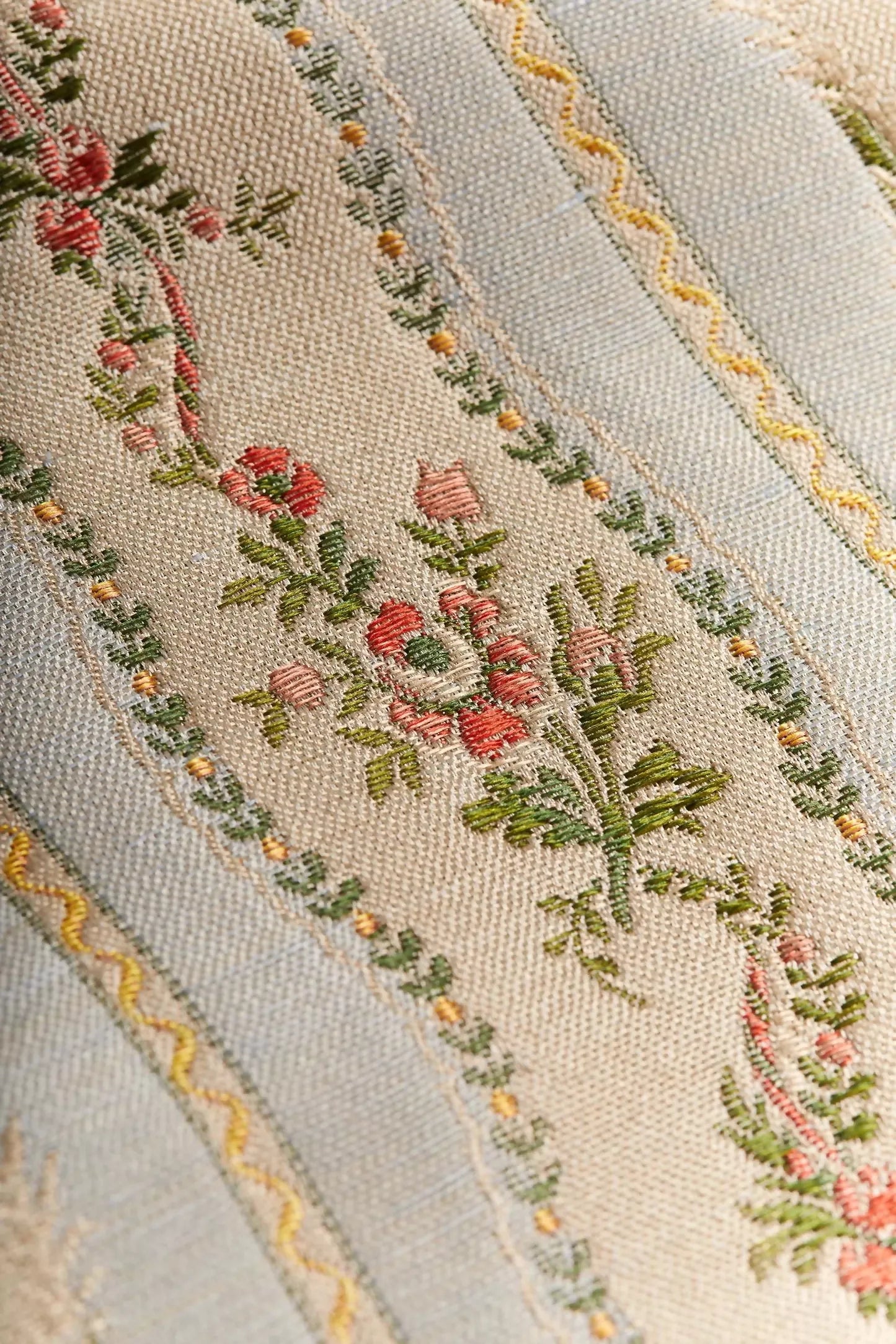 Close-up of Spitalfields stripe sky fabric featuring a jacquard weave with floral motifs and silk leaves, in a warm honey tone,  available  to buy on the-salon.com. SALON curates the finest , unique, handmade pieces from the interior industry's best makers and brands. Shop luxury furniture, lighting, rugs, art, antiques and vintage pieces and accessories from SALON interior designed rooms.