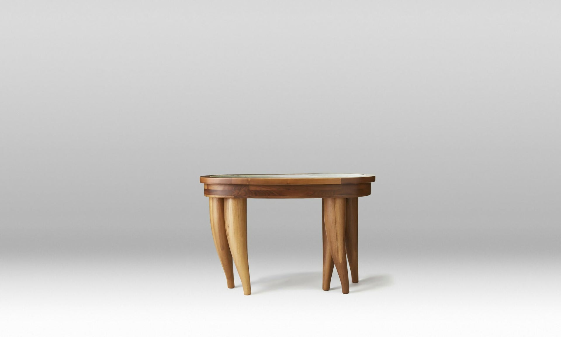 A wooden desk with a curved, organic shape and solid wood legs, featuring a marble top with brass hardware and leather inlay drawers,  available  to buy on the-salon.com. SALON curates the finest , unique, handmade pieces from the interior industry's best makers and brands. Shop luxury furniture, lighting, rugs, art, antiques and vintage pieces and accessories from SALON interior designed rooms.