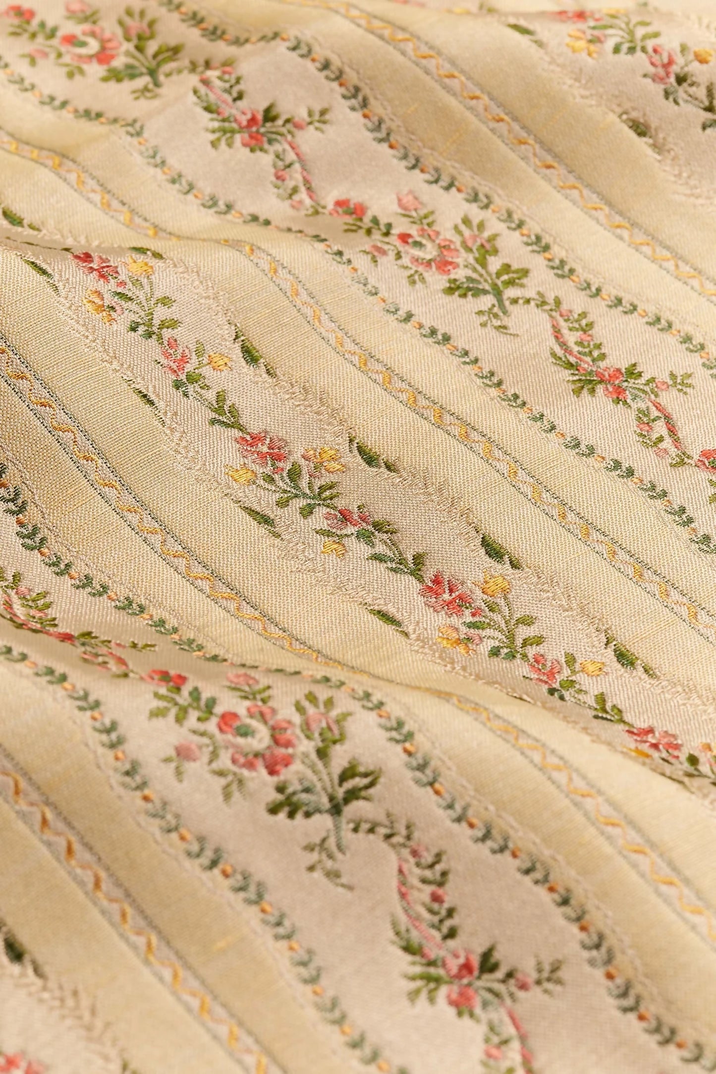 Close-up of Spitalfields stripe straw fabric with a jacquard weave, featuring floral motifs and silk leaves, in a warm honey tone,  available  to buy on the-salon.com. SALON curates the finest , unique, handmade pieces from the interior industry's best makers and brands. Shop luxury furniture, lighting, rugs, art, antiques and vintage pieces and accessories from SALON interior designed rooms.