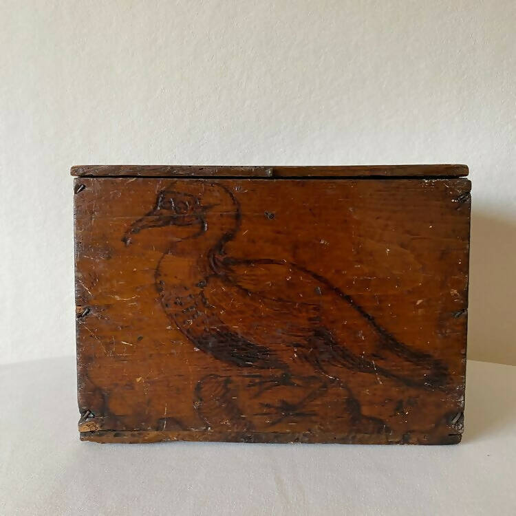 An 1800s wooden box with a carved bird, identified as a 'Pelican', on its surface, available  to buy on the-salon.com. SALON curates the finest , unique, handmade pieces from the interior industry's best makers and brands. Shop luxury furniture, lighting, rugs, art, antiques and vintage pieces and accessories from SALON interior designed rooms.
