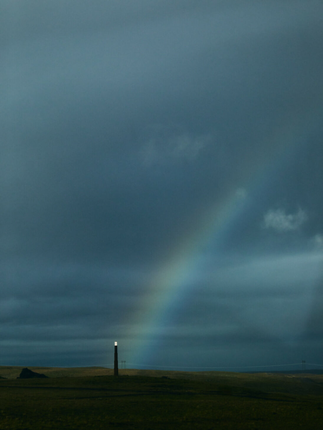 An image of a lighthouse under a rainbow in a dark sky,  available  to buy on the-salon.com. SALON curates the finest , unique, handmade pieces from the interior industry's best makers and brands. Shop luxury furniture, lighting, rugs, art, antiques and vintage pieces and accessories from SALON interior designed rooms.