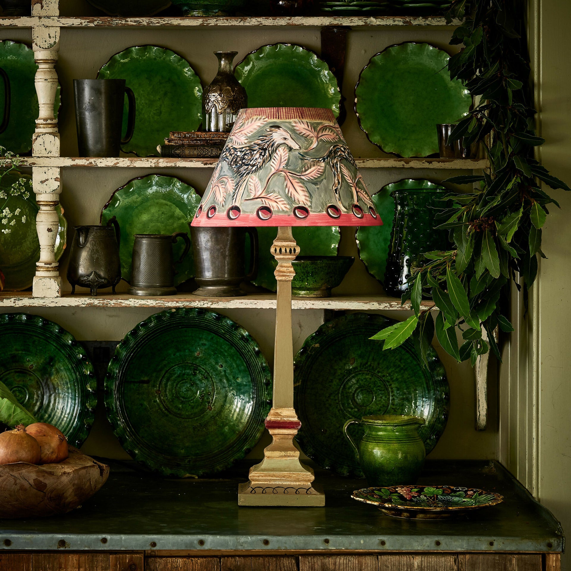 Decorative lamp with green lampshade on a shelf with green plates and jars,  available  to buy on the-salon.com. SALON curates the finest , unique, handmade pieces from the interior industry's best makers and brands. Shop luxury furniture, lighting, rugs, art, antiques and vintage pieces and accessories from SALON interior designed rooms.