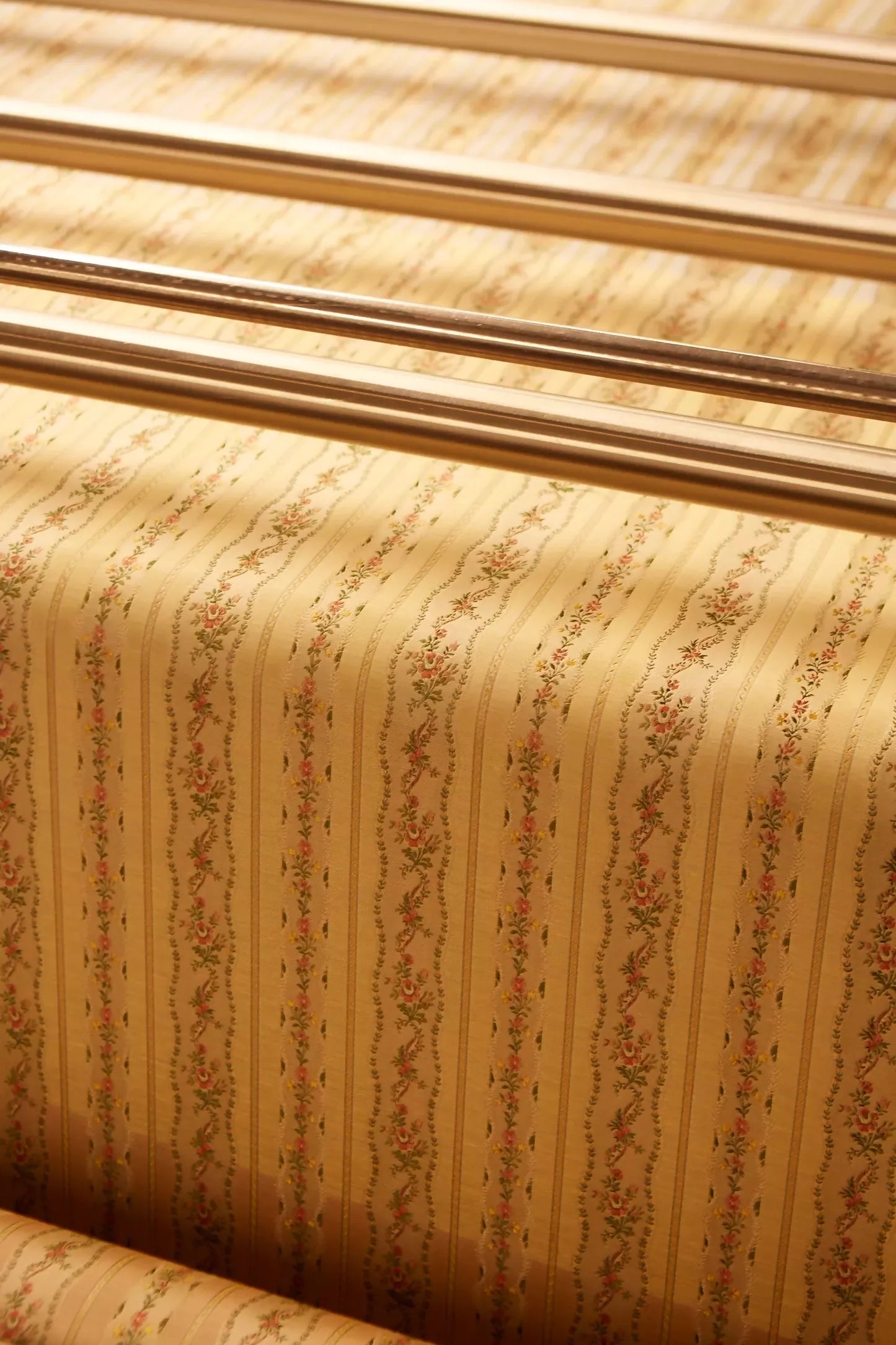 Close-up of Spitalfields stripe straw fabric with a jacquard weave, featuring floral motifs and silk leaves, in a warm honey tone,  available  to buy on the-salon.com. SALON curates the finest , unique, handmade pieces from the interior industry's best makers and brands. Shop luxury furniture, lighting, rugs, art, antiques and vintage pieces and accessories from SALON interior designed rooms.