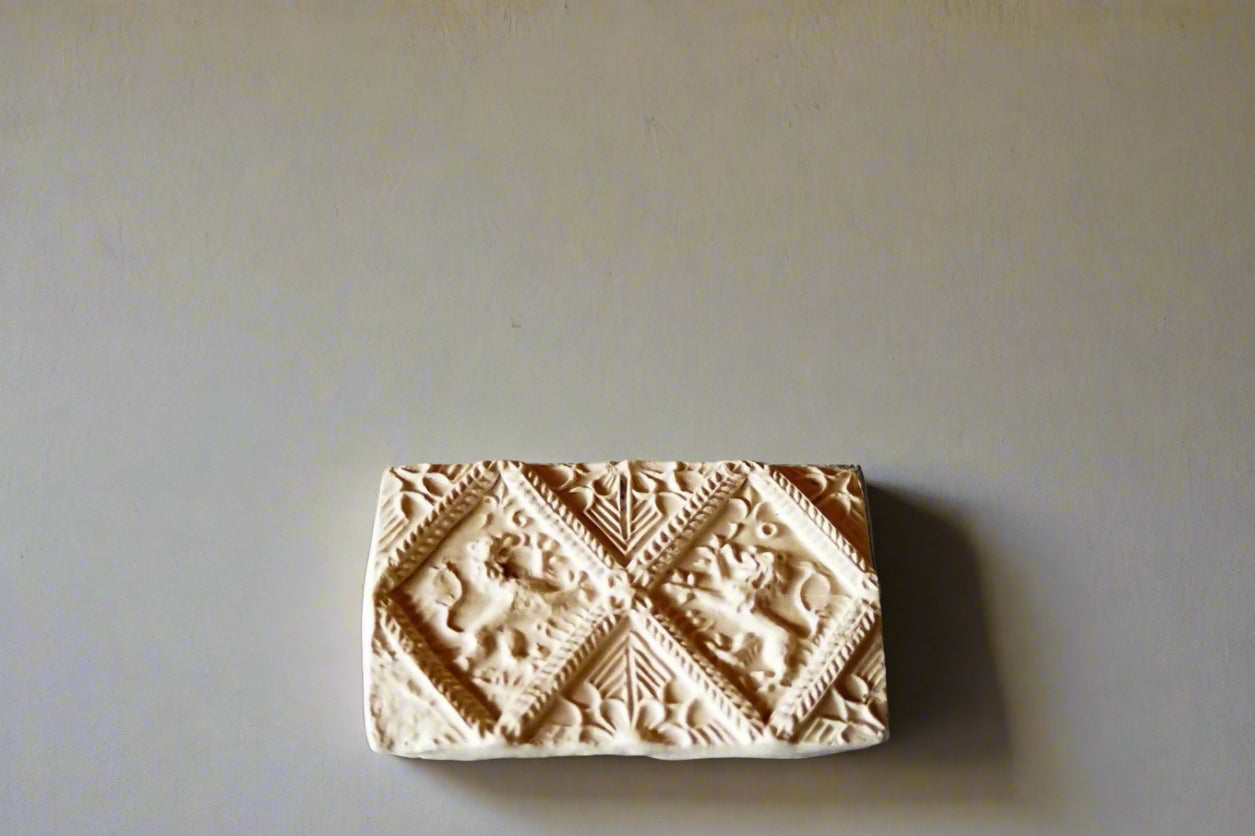 A plaster cast of a Jacobean brick with decorative patterns, including a pair of lions rampant, placed against a stone wall on a dark surface,  available  to buy on the-salon.com. SALON curates the finest , unique, handmade pieces from the interior industry's best makers and brands. Shop luxury furniture, lighting, rugs, art, antiques and vintage pieces and accessories from SALON interior designed rooms.