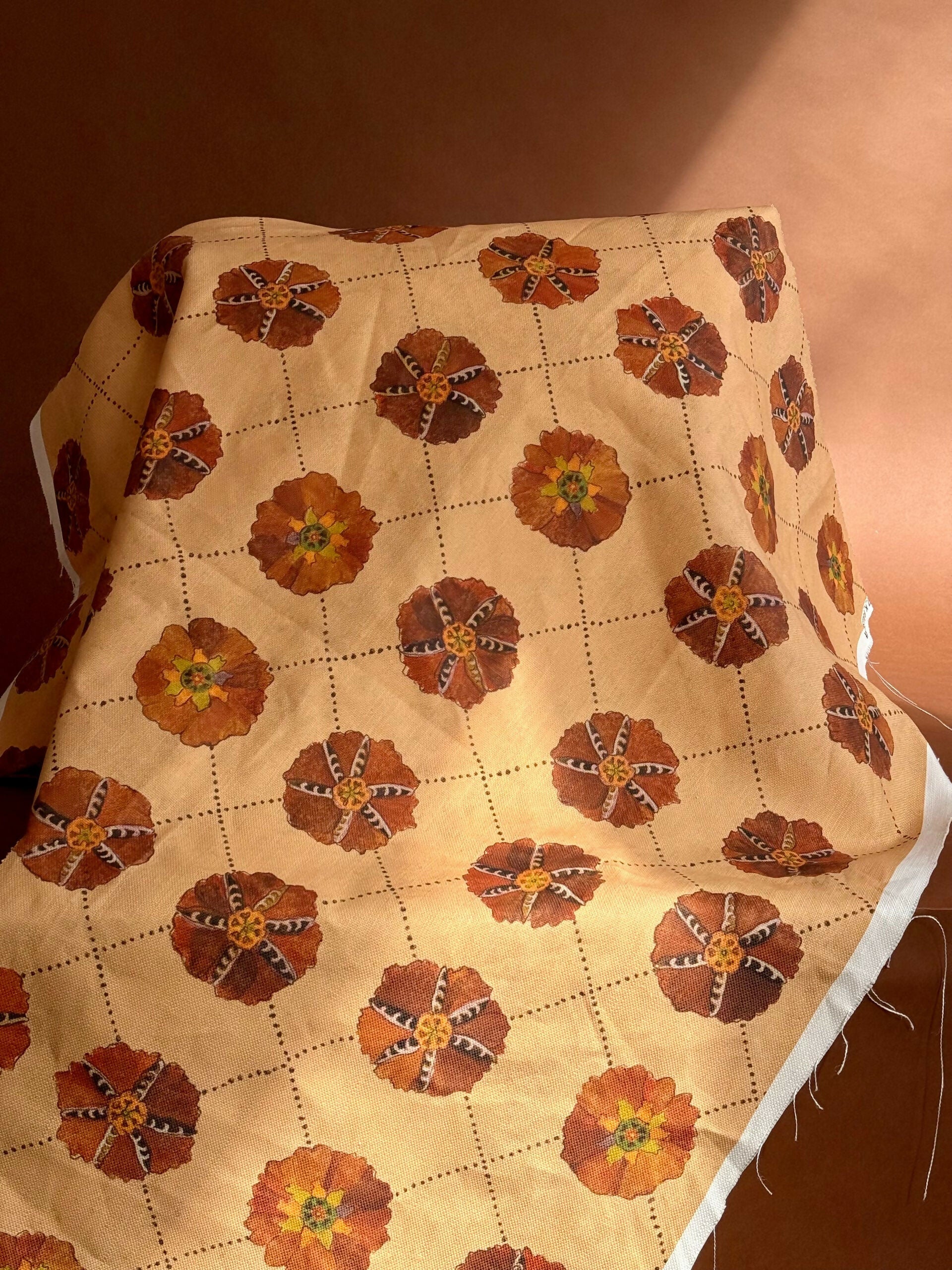 A piece of suzani fabric with floral patterns in beige, brown, and multicolor hues,  available  to buy on the-salon.com. SALON curates the finest , unique, handmade pieces from the interior industry's best makers and brands. Shop luxury furniture, lighting, rugs, art, antiques and vintage pieces and accessories from SALON interior designed rooms.