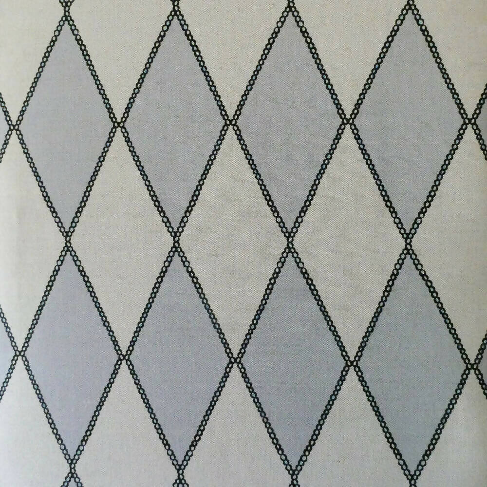 Close-up of a fabric with a geometric harlequin pattern in pearl white and grey colors, available  to buy on the-salon.com. SALON curates the finest , unique, handmade pieces from the interior industry's best makers and brands. Shop luxury furniture, lighting, rugs, art, antiques and vintage pieces and accessories from SALON interior designed rooms.