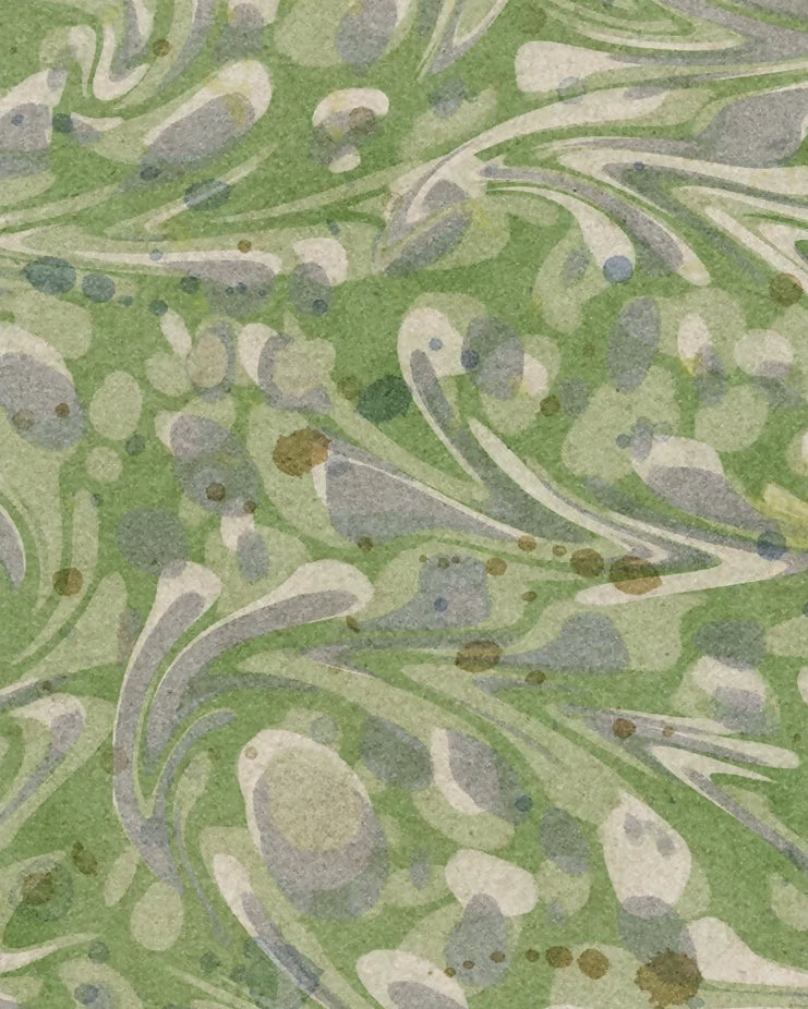 A square fabric or material swatch with scalloped edges, showing an abstract marbled pattern in muted green, gray, beige, and small brown speckles.