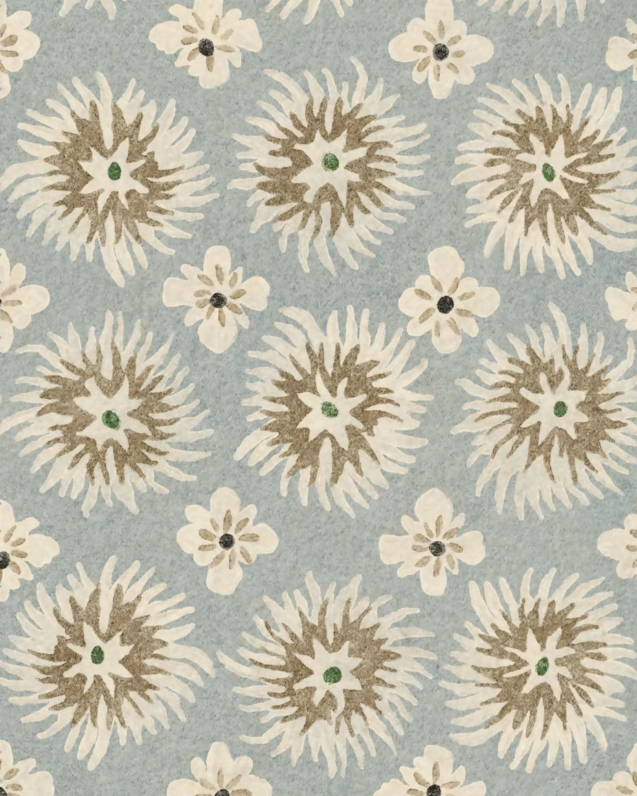 A square fabric or carpet swatch with a scalloped edge, featuring a repeating floral pattern in cream, tan, and olive green on a muted light blue-gray background.