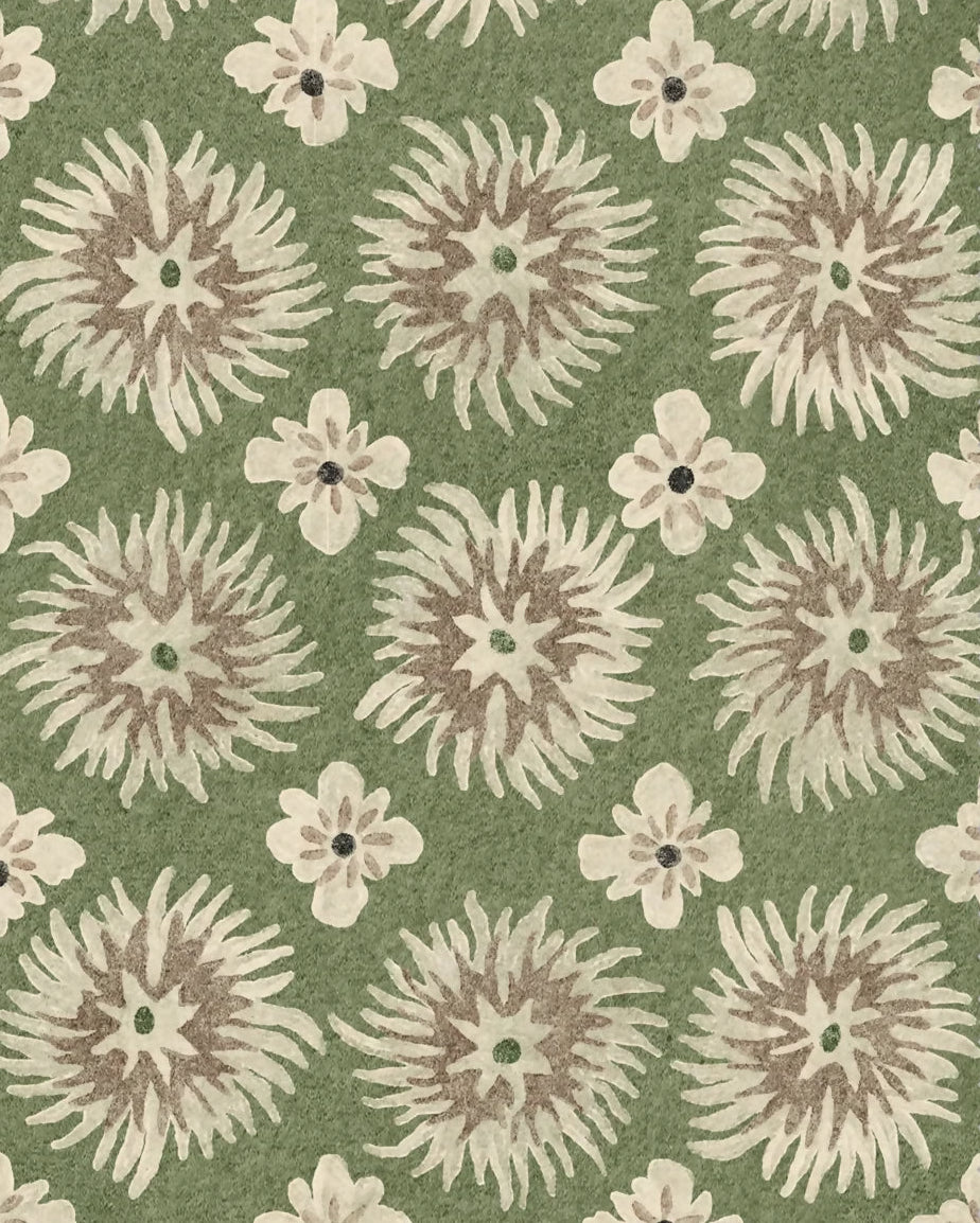 A close-up of a fabric or rug swatch with a repeating floral pattern. The design features large, textured cream and taupe starburst medallions interspersed with small cream flowers on an olive green background.