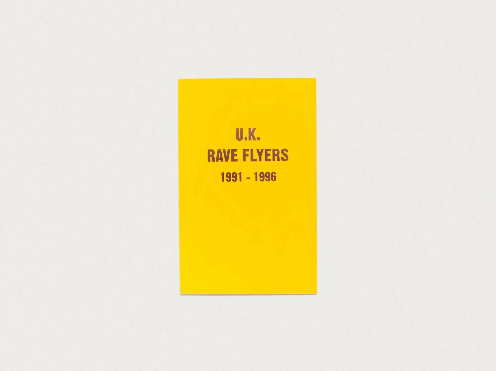Cover of the book 'UK RAVE FLYERS 1991-1996' with a yellow background and black text,  available  to buy on the-salon.com. SALON curates the finest , unique, handmade pieces from the interior industry's best makers and brands. Shop luxury furniture, lighting, rugs, art, antiques and vintage pieces and accessories from SALON interior designed rooms.