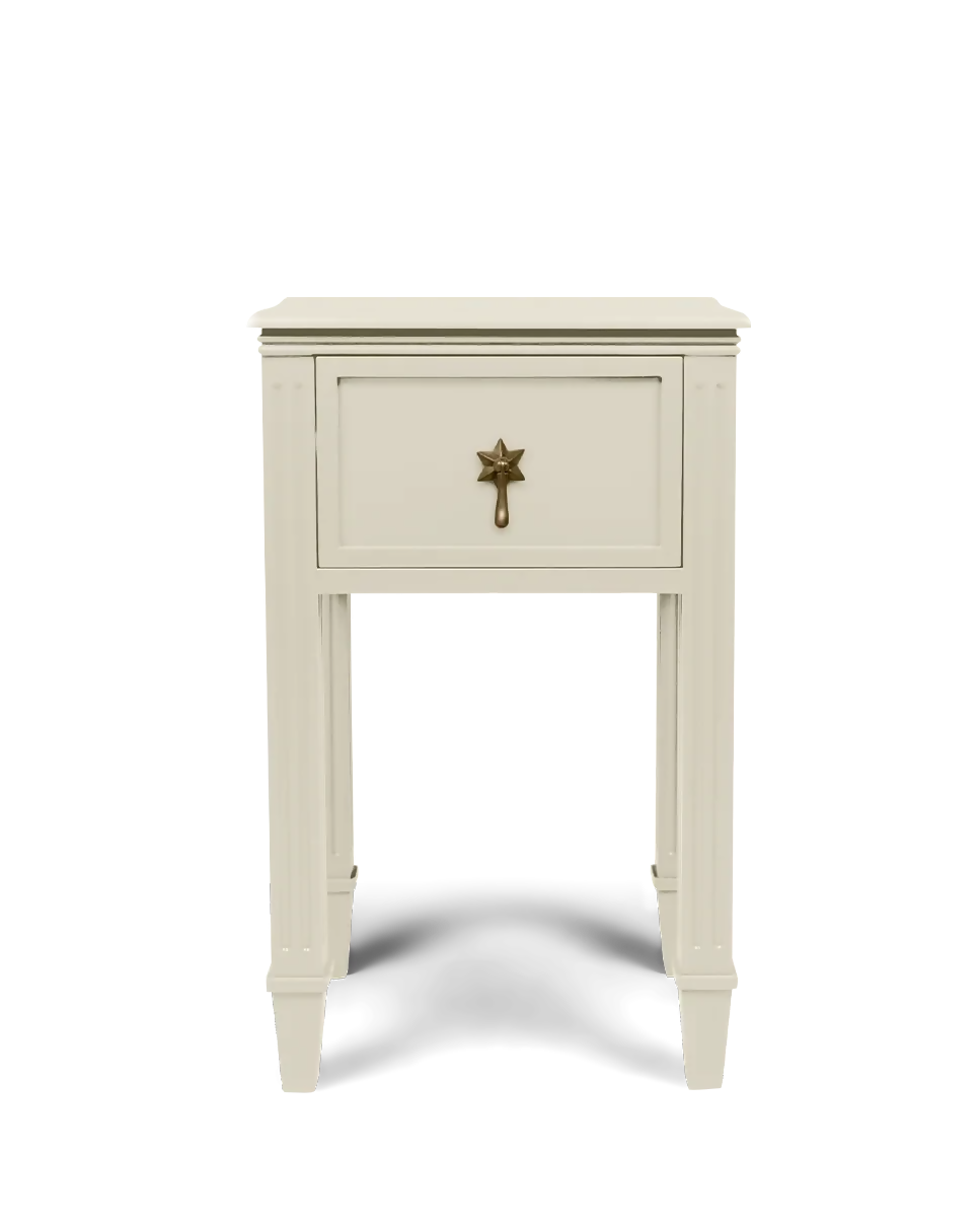 A small cream-colored wooden nightstand with a single drawer and a decorative brass star-shaped pull handle, shown against a plain white background.