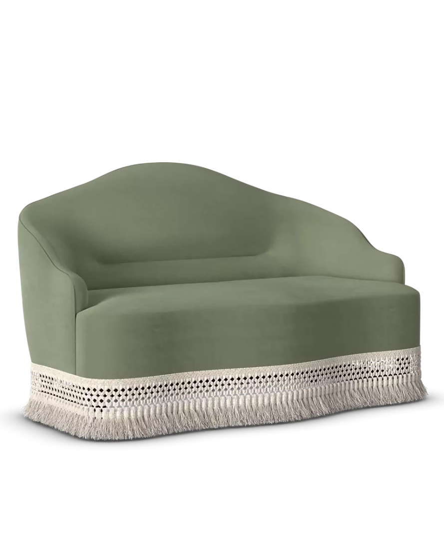 A modern lounge chair upholstered in sage green fabric with a cream-colored fringed trim at the base, shown against a plain white background.