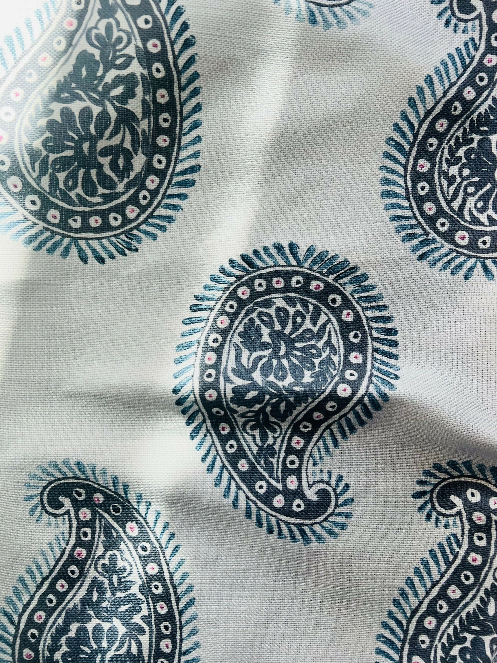Close-up of a paisley patterned fabric with a design consisting of teardrop shapes and floral elements, predominantly in dark colors on a light background,available  to buy on the-salon.com. SALON curates the finest , unique, handmade pieces from the interior industry's best makers and brands. Shop luxury furniture, lighting, rugs, art, antiques and vintage pieces and accessories from SALON interior designed rooms