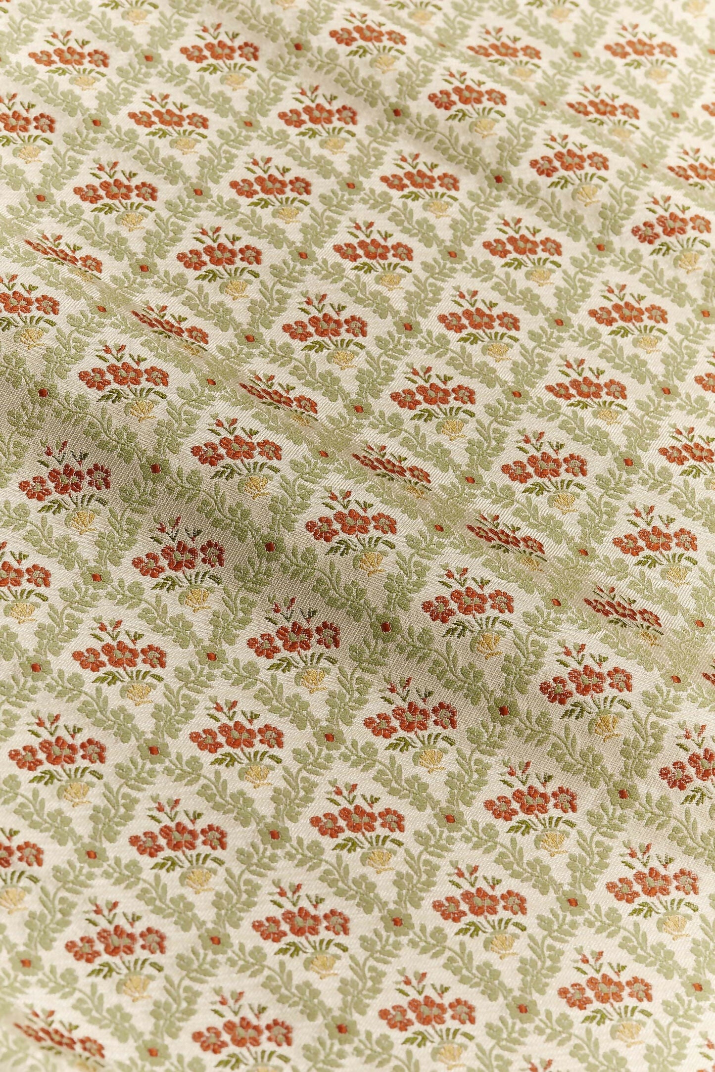 A textile fabric with a jacquard weave pattern featuring vibrant red poppies in a scallop shell vase, surrounded by foliage arranged in a trellis style,  available  to buy on the-salon.com. SALON curates the finest , unique, handmade pieces from the interior industry's best makers and brands. Shop luxury furniture, lighting, rugs, art, antiques and vintage pieces and accessories from SALON interior designed rooms.