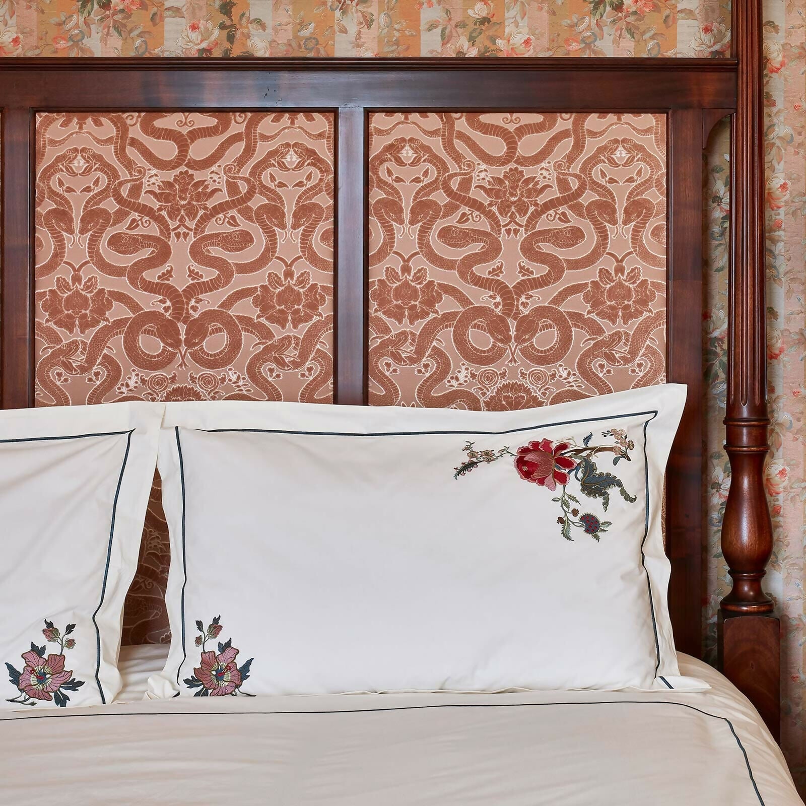 Decorative pillows with floral embroidery on a bed with a patterned headboard,  available  to buy on the-salon.com. SALON curates the finest , unique, handmade pieces from the interior industry's best makers and brands. Shop luxury furniture, lighting, rugs, art, antiques and vintage pieces and accessories from SALON interior designed rooms.