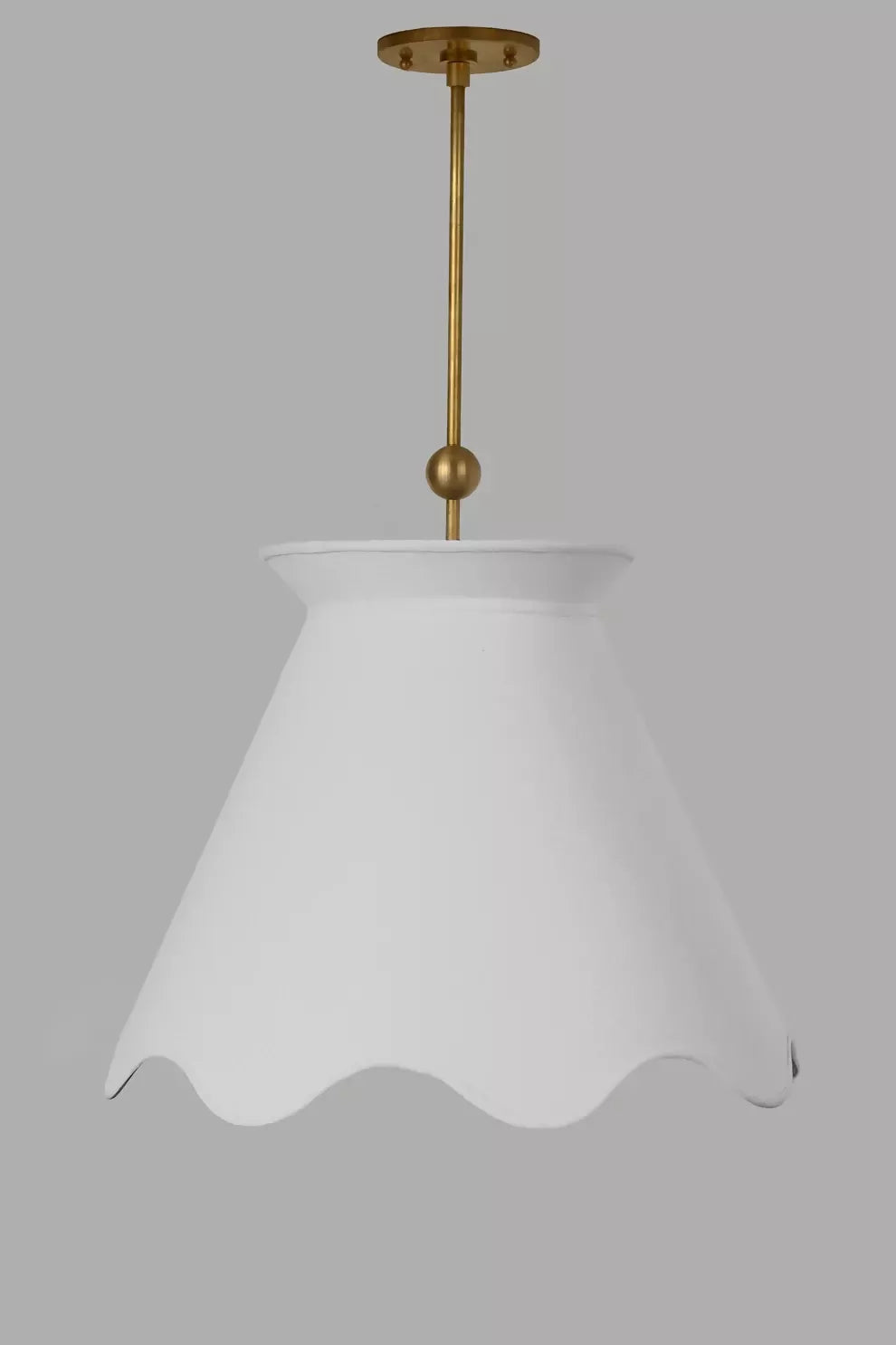A pendant light with a pleated shade hanging over a dining table with a floral arrangement in the center, with curtains in the background, available  to buy on the-salon.com. SALON curates the finest , unique, handmade pieces from the interior industry's best makers and brands. Shop luxury furniture, lighting, rugs, art, antiques and vintage pieces and accessories from SALON interior designed rooms.