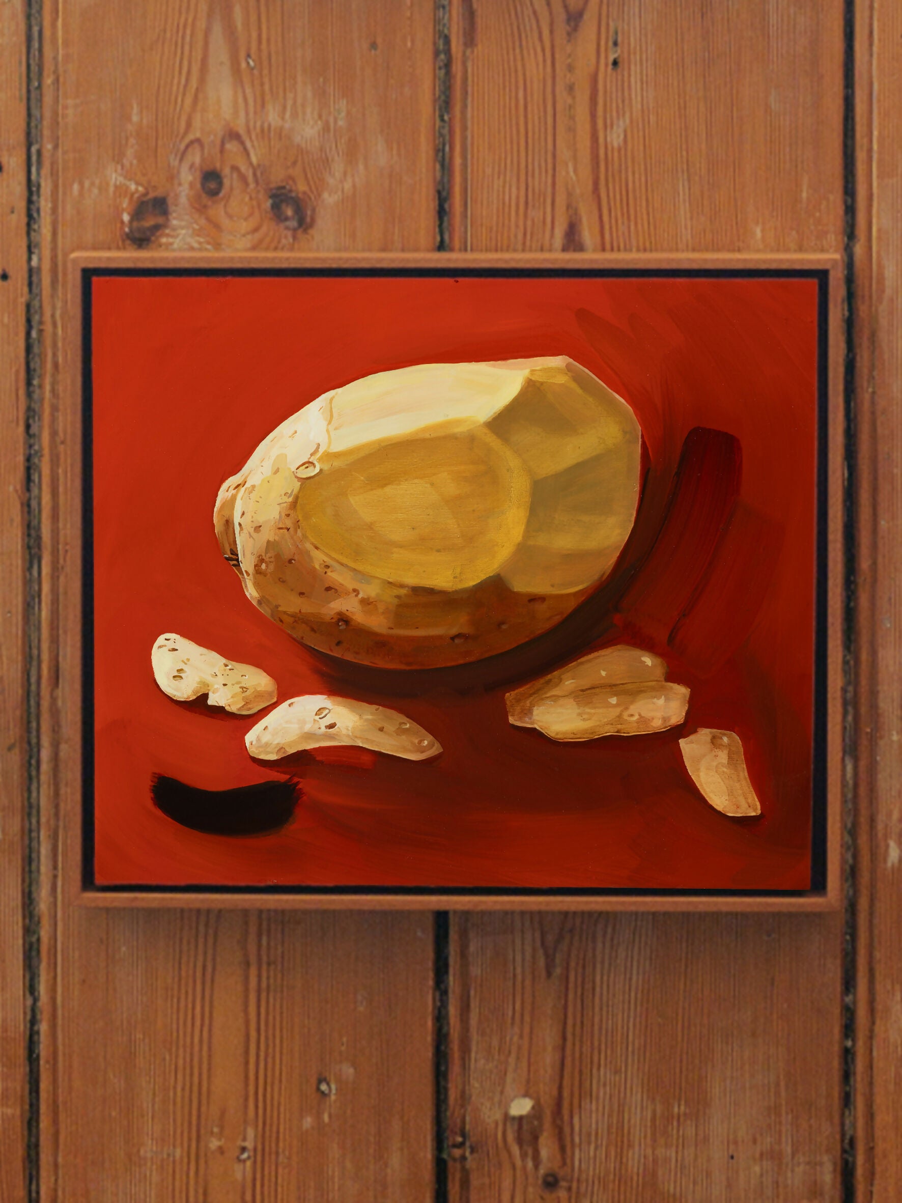 A framed oil painting of a peeled potato and a slice of potato against a red background, by Sophie Glover,  available  to buy on the-salon.com. SALON curates the finest , unique, handmade pieces from the interior industry's best makers and brands. Shop luxury furniture, lighting, rugs, art, antiques and vintage pieces and accessories from SALON interior designed rooms.