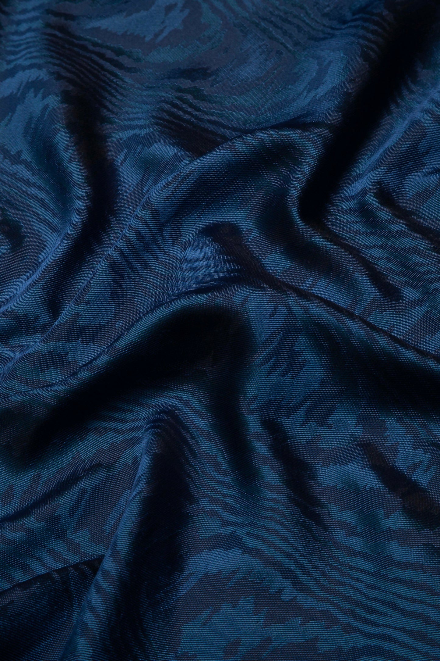 Close-up of a blue moiré pattern fabric texture,  available  to buy on the-salon.com. SALON curates the finest , unique, handmade pieces from the interior industry's best makers and brands. Shop luxury furniture, lighting, rugs, art, antiques and vintage pieces and accessories from SALON interior designed rooms.