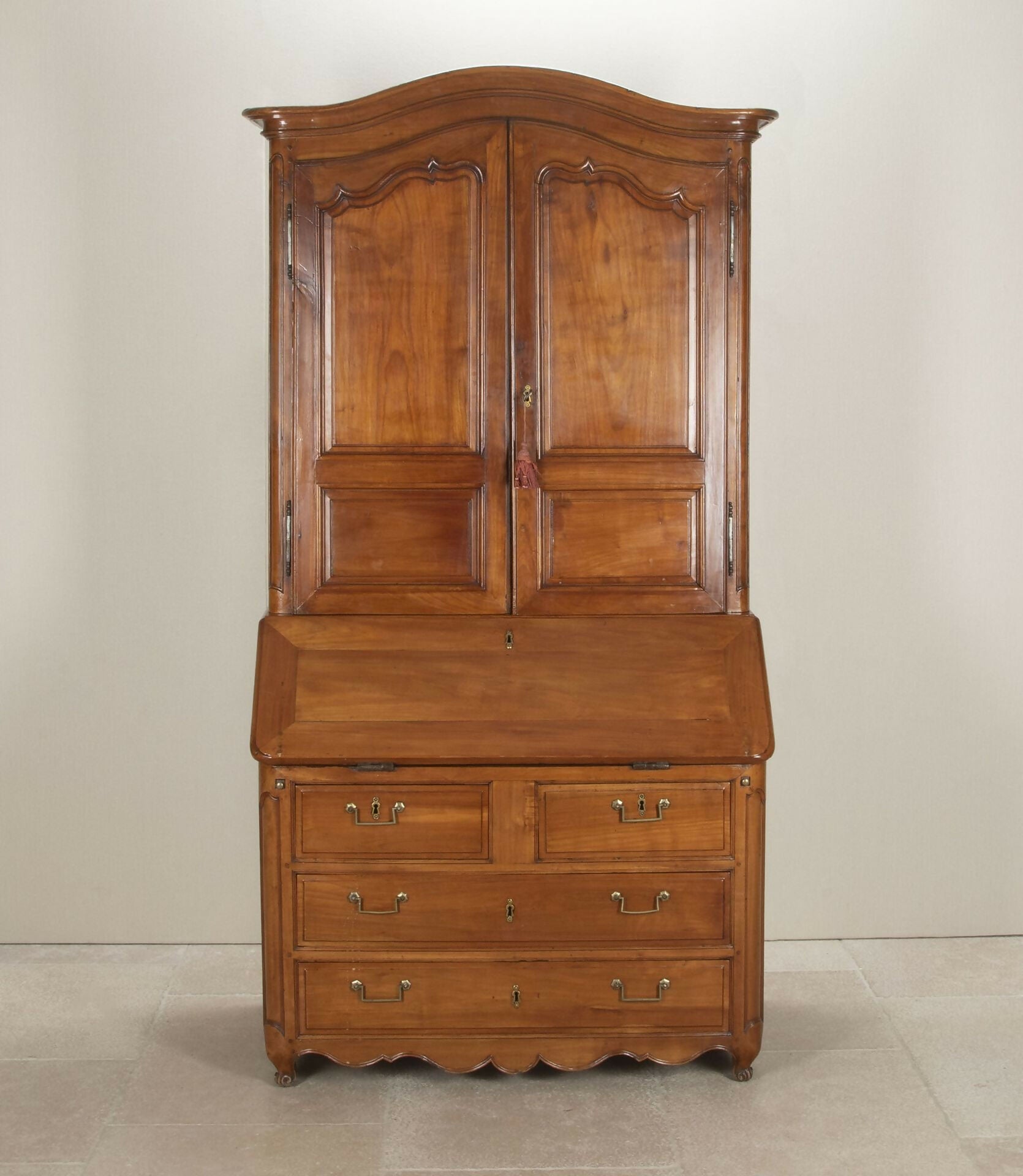 Wooden wardrobe with two doors and multiple drawers on a plain background,  available  to buy on the-salon.com. SALON curates the finest , unique, handmade pieces from the interior industry's best makers and brands. Shop luxury furniture, lighting, rugs, art, antiques and vintage pieces and accessories from SALON interior designed rooms.