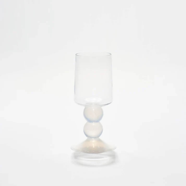 A white wine glass with a unique spherical and diamond stacked stem design, with a clear glass body and foot,  available  to buy on the-salon.com. SALON curates the finest , unique, handmade pieces from the interior industry's best makers and brands. Shop luxury furniture, lighting, rugs, art, antiques and vintage pieces and accessories from SALON interior designed rooms.