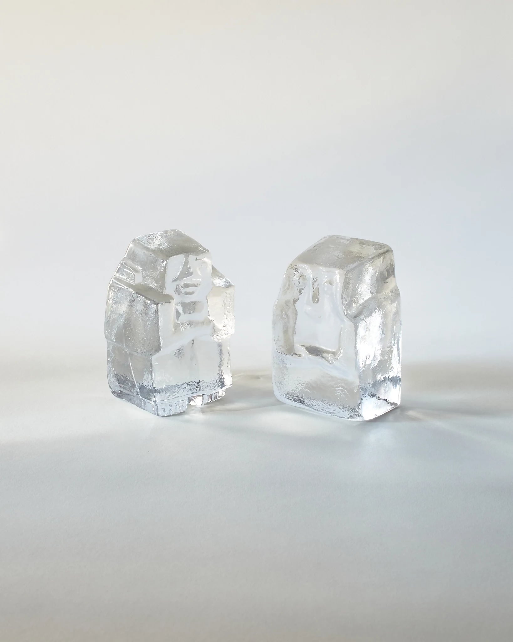A pair of clear glass figurative bookends designed by Erik Höglund for Kosta Boda, resembling ice carvings,  available  to buy on the-salon.com. SALON curates the finest , unique, handmade pieces from the interior industry's best makers and brands. Shop luxury furniture, lighting, rugs, art, antiques and vintage pieces and accessories from SALON interior designed rooms.