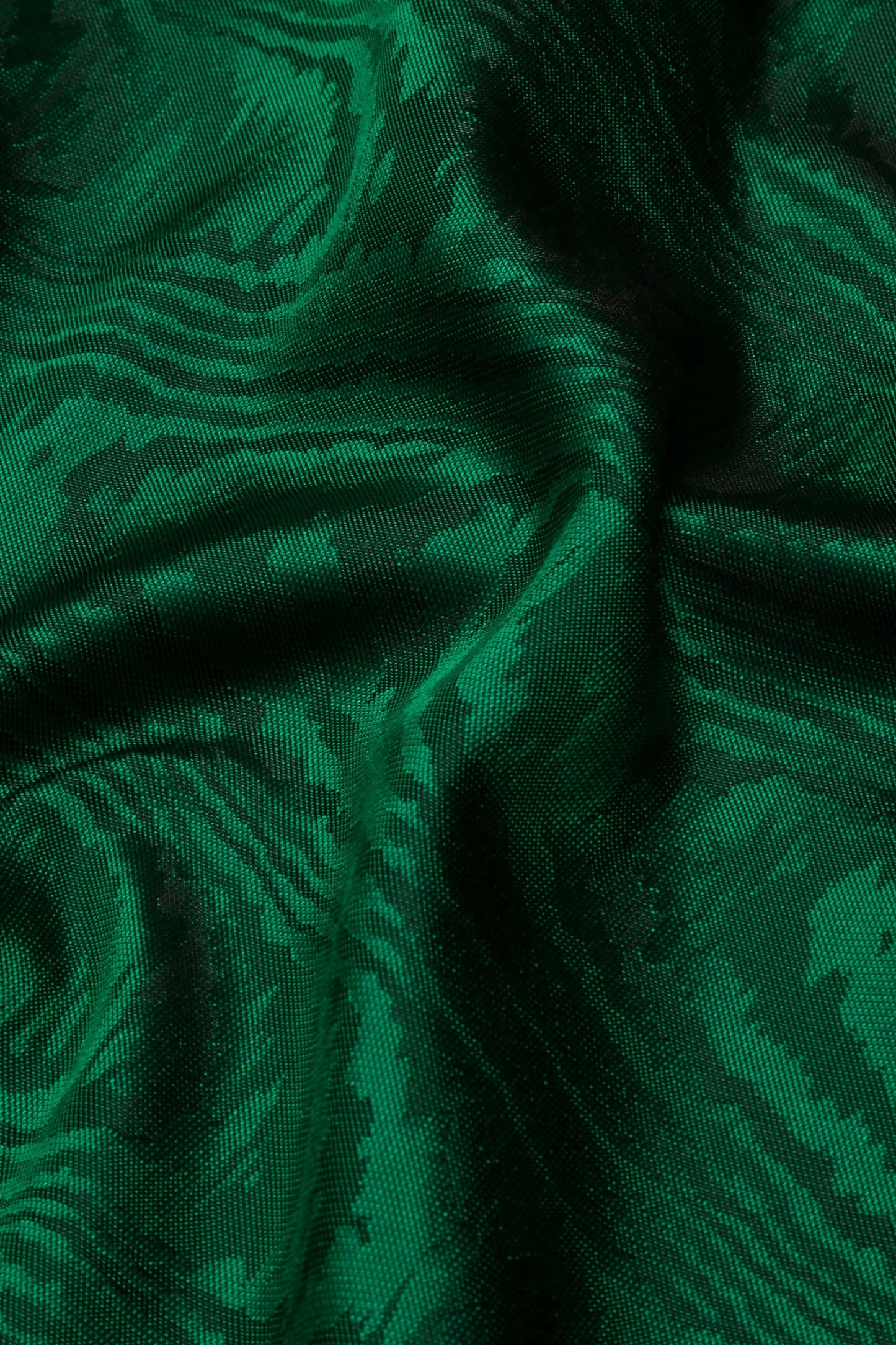 Close-up view of a green silk moiré fabric with a textured pattern,  available  to buy on the-salon.com. SALON curates the finest , unique, handmade pieces from the interior industry's best makers and brands. Shop luxury furniture, lighting, rugs, art, antiques and vintage pieces and accessories from SALON interior designed rooms.